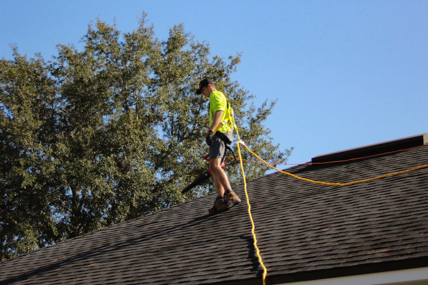 Roofer repairing shingles on residential roof